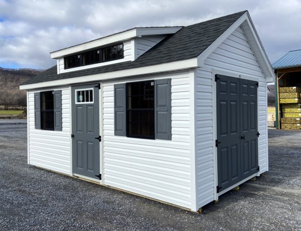 white studio shed with blue trimming and black out windows