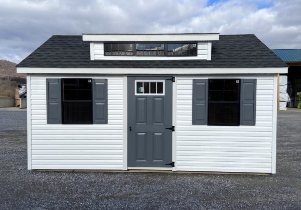 white studio shed with blue trimming and black out windows